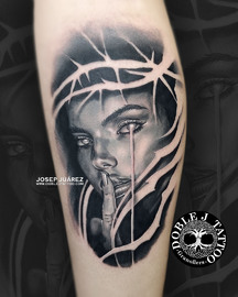 Retrato surrealista en negro y grises Tatuaje realista de retrato detallado en blanco y gris en el lateral del gemelo izquierdo, realizado en el estudio Doble J Tattoo en Granollers.