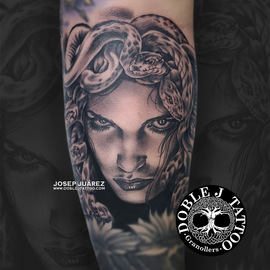 Medusa Retrato Tatuaje realista de retrato de Medusa detallado en blanco y negro en el brazo izquierdo, realizado en el estudio Doble J Tattoo en Granollers.