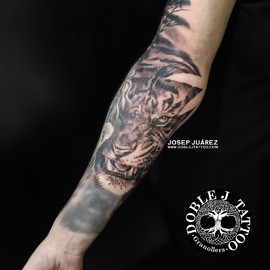 Tatuaje de tigre realista con sombras y texturas detalladas en el antebrazo, diseño personalizado por Doble J Tattoo.